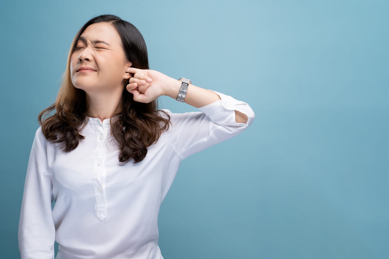Woman putting finger in ear