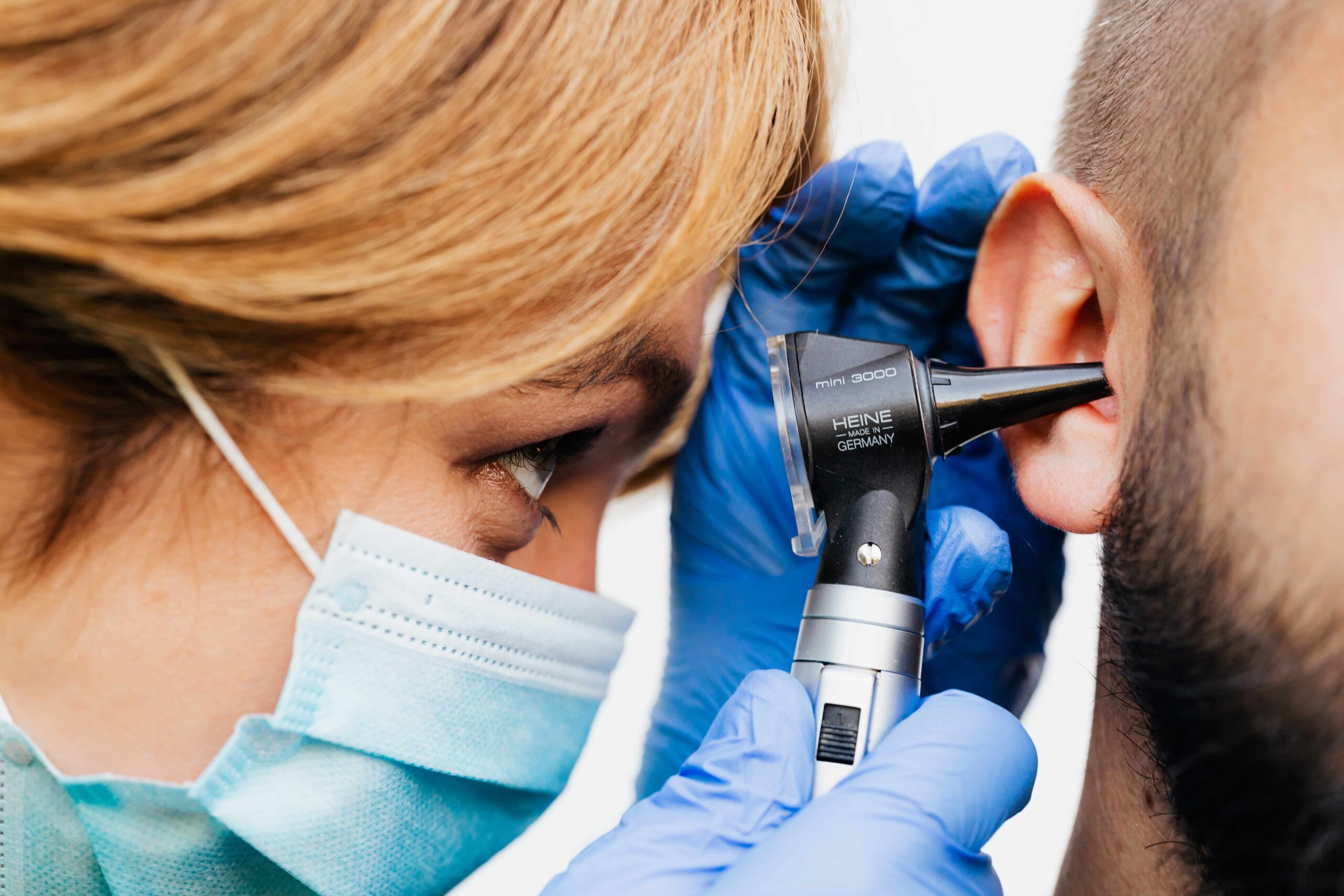 Close up of doctor examining a man's ear.