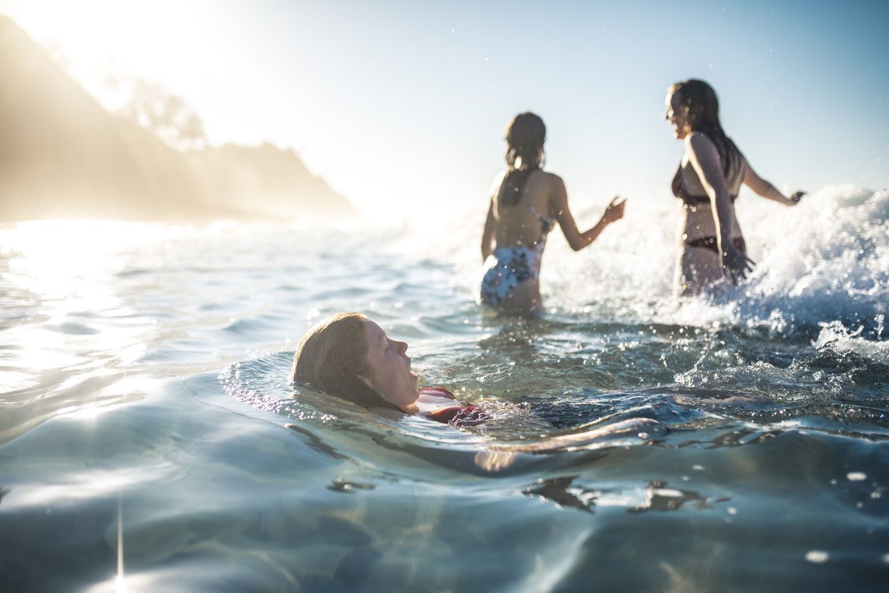 Three young kids swimming at the beach