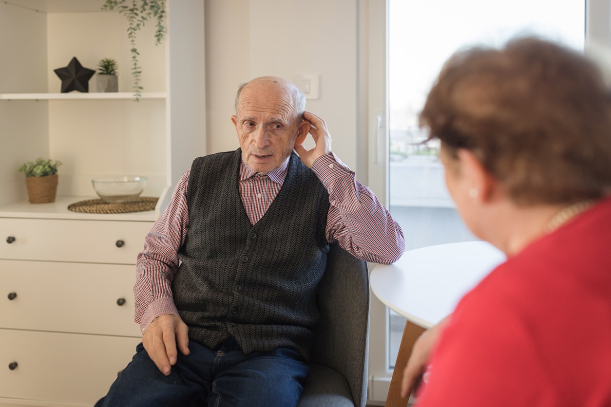 Man cups ear in effort to hear