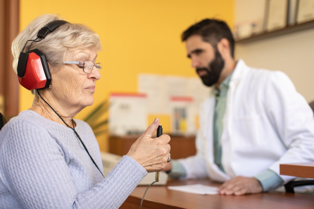 Senior woman taking a pure tone hearing test